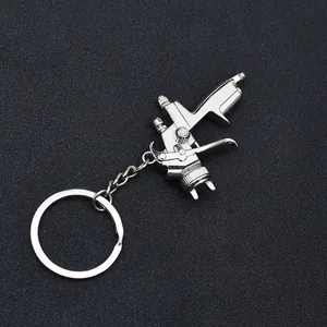 Macro shot of silver metal water spray gun keychain with realistic trigger details