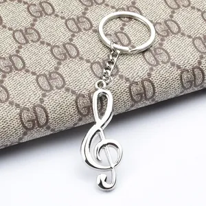 Dettaglio del portachiavi a forma di chiave di violino argento su sfondo con trama moda