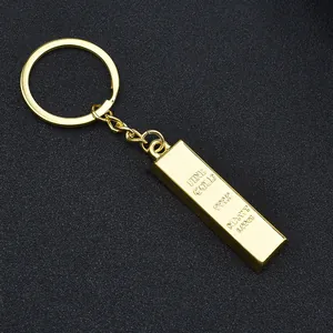 Macro shot of gold bar keychain with fine gold 999.9 engraving on black background