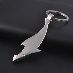 Polished shark-shaped metal keychain with functional bottle opener feature on dark leather