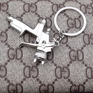 Polished silver zinc alloy spray gun keychain with detailed trigger and nozzle pendant