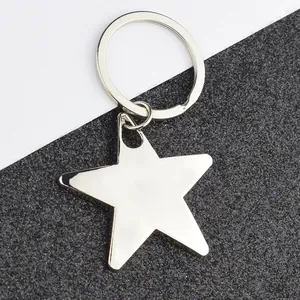 Polished silver metal star keychain with round ring on black and white background