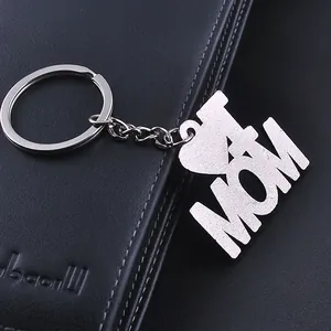 Polished silver metal I Love Mom keychain pendant on black leather texture background