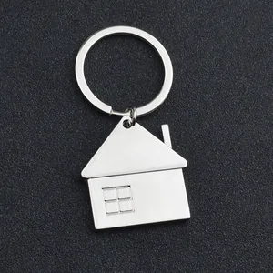 Porte-clés maison en métal argenté poli avec détails de fenêtre sur fond gris foncé
