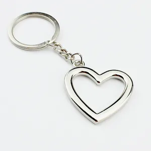 Polished silver hollow heart keychain with metallic ring and chain on white background
