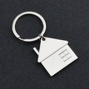 Porte-clés maison en métal poli argenté avec anneau plat sur fond texturé gris