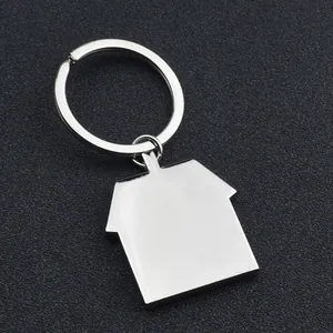 Polished silver metal house-shaped keychain on a dark textured background