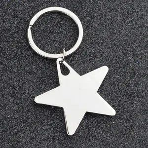 Polished silver metal star keychain with a round ring on a textured black background