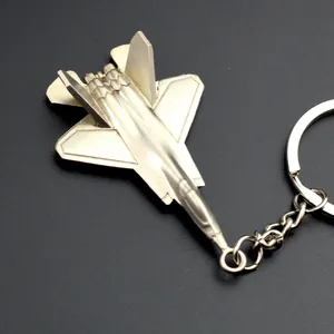 Silver metallic J-35A stealth fighter jet keychain on a textured black background