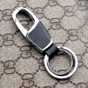 Detail of luxury leather keychain with polished silver metal hook and double rings
