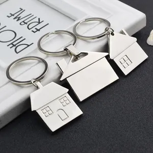Set of three silver metal house-shaped keychains with polished finish and embossed details