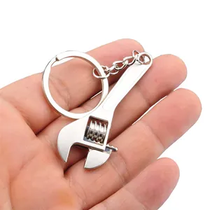 Mini portachiavi con chiave inglese regolabile in argento tenuto in mano per mostrare la misura
