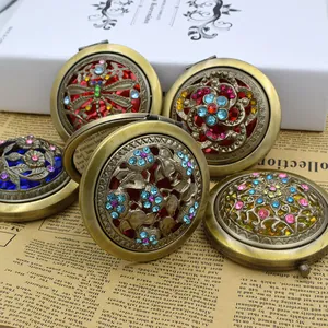 Vintage bronze pocket mirrors with intricate hollow carvings and colorful rhinestones