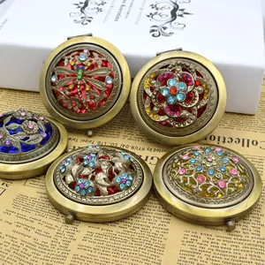 Macro detail of vintage hollow metal makeup mirrors with colorful rhinestone dragonfly motifs