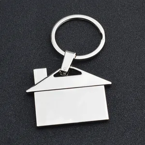 Polished silver house-shaped metal keychain with chimney on dark textured background
