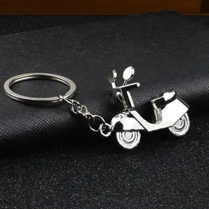 Polierter silberner Metall-Motorroller-Schlüsselanhänger mit rundem Ring auf schwarzem Leder