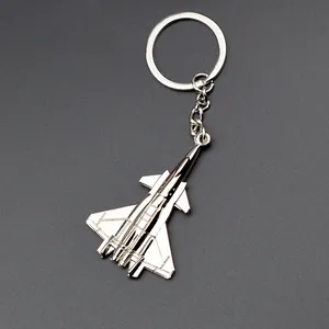 Macro shot of silver fighter jet keychain showing detailed wings and polished metal finish