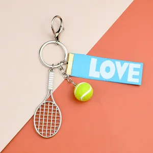 Dettaglio del portachiavi da tennis con mini racchetta, pallina e nastro blu con LOVE