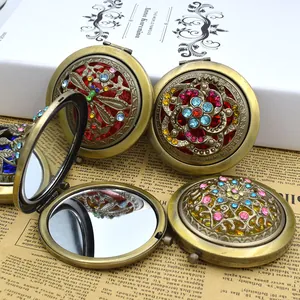Detail of vintage bronze hollow makeup mirror with colorful rhinestones and floral design