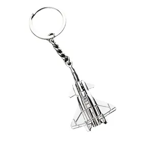Polished silver metal fighter jet keychain with triangular wing design on white background