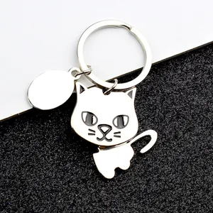 Close-up of a silver-plated metal cat keychain with black enamel details and oval tag