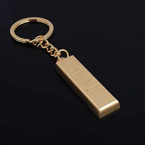 Macro view of a gold-plated bar keychain with fine gold 999.9 engraving on black mirror