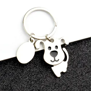 Detalle de un llavero de perrito en metal brillante con placa ovalada para personalización