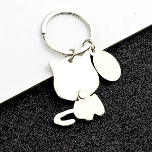 Silver metal cat keychain with movable joints and blank oval tag on white background