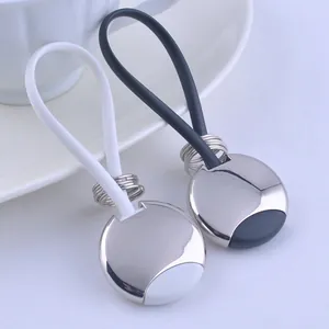 Detail view of black and white silicone car keychains with polished metal rings and bases