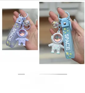 Close-up of glowing astronaut sunset lamp keychains with silicone space wristbands