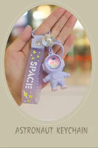 Macro view of purple astronaut keychain with a soft strap and space themed pendant