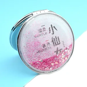 Macro view of quicksand glitter heart pattern on silver round compact makeup mirror