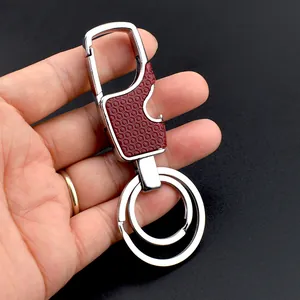 Detailed close-up of a metal keychain bottle opener with textured red honeycomb grip inlay