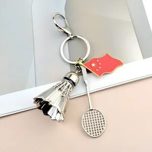 Metal badminton keychain featuring shuttlecock, racket, and flag charms on polished alloy