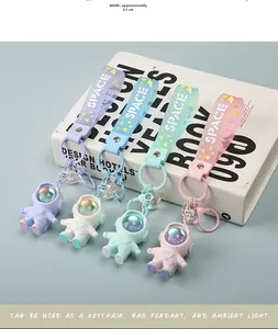 Size detail of four colorful astronaut keychains with translucent space straps