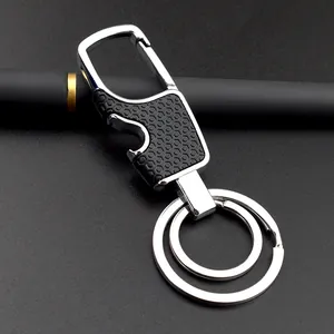 Dual-ring metal keychain with bottle opener and black honeycomb grip on dark surface