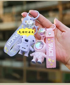 Detail of astronaut keychain featuring ambient light switch and purple silicone strap