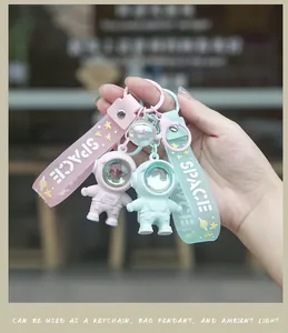 Detail of pink and green astronaut keychains with glowing ambient light and wrist straps