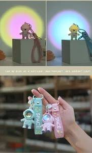 Glow-in-the-dark astronaut keychain showing LED light effect and soft silicone hand strap