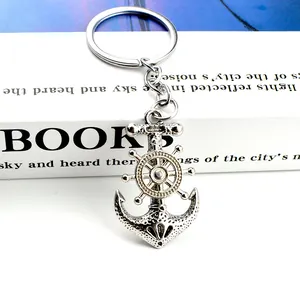 Close-up of vintage pirate anchor and ship wheel keychain with retro metallic texture