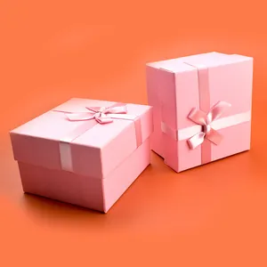 Pink gift box set with satin ribbons for jewelry packaging on orange background