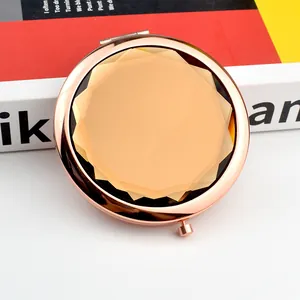 Detail of rose gold portable makeup mirror featuring faceted champagne crystal inlay