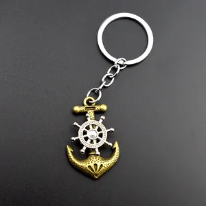 Detailed close-up of a vintage nautical keychain with a bronze anchor and spinning helm wheel