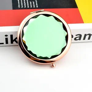 Foldable rose gold makeup mirror with a faceted light green crystal top for ladies