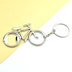 Detalle de llavero de bicicleta de metal con abrebotellas y acabado plateado pulido