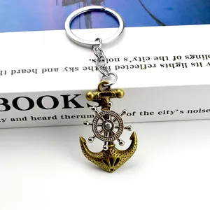 Vintage nautical keychain featuring a bronze anchor and silver rotating ship steering wheel