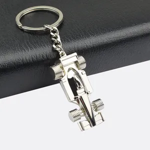 Polished silver F1 racing car keychain on premium black leather and grey background