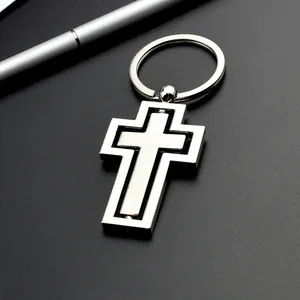 Vue détaillée d'un porte-clés croix rotative en métal argenté sur fond noir élégant