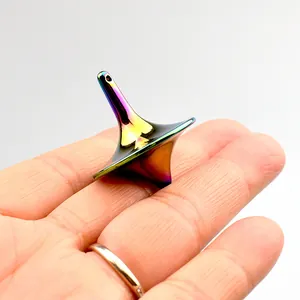 Rainbow plated metal fidget spinner toy shown on a fingertip for scale reference