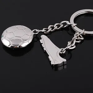 Metallic soccer keychain with football and shoe charms on a reflective black background